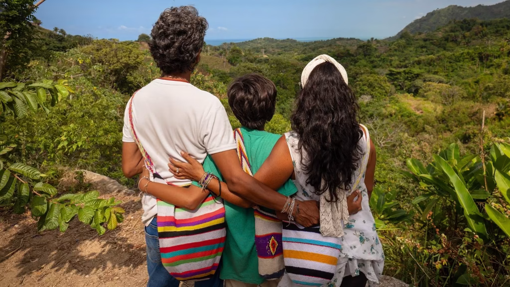 A family of three looks to the horizon during the midday in the Sierra de Santa Marta